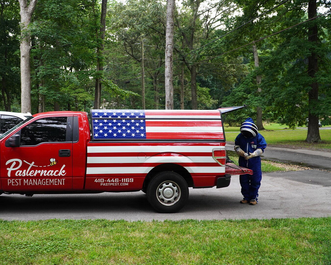 Pasternack Pest Management truck loaded with equipment and a suited technician at the tailgate